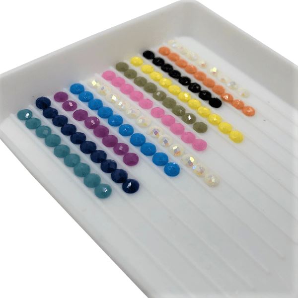 Bunte Diamond Painting Steine in einer Sortierschale für das Dinosaurier DIY-Sticker Set
