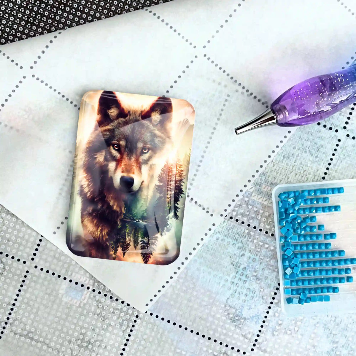 Glas Cover Minder mit Wolf-Motiv als praktisches Zubehör für Diamond Painting auf einer Leinwand mit Stift und Steinchen.